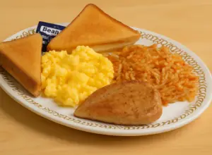 breakfast plate with chicken breast scrambled egg with bread.
